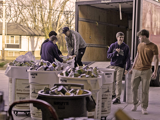 Volunteers loading canned goods into a truck