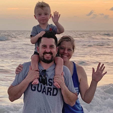 Adoptive parents with son on beach