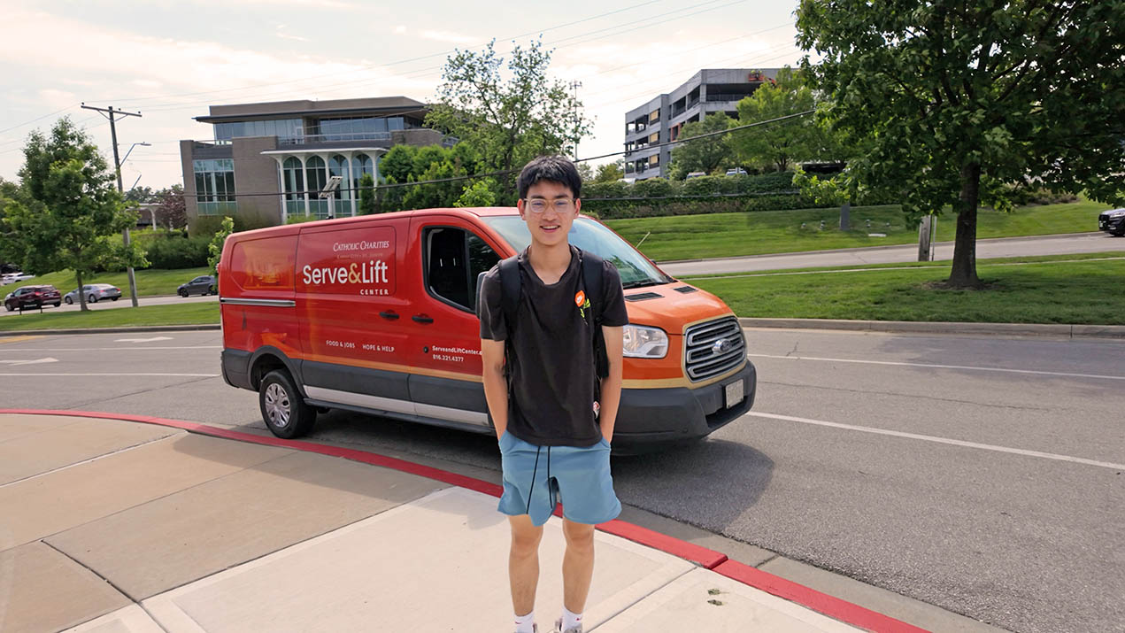 Young man standing by Serve & Lift van