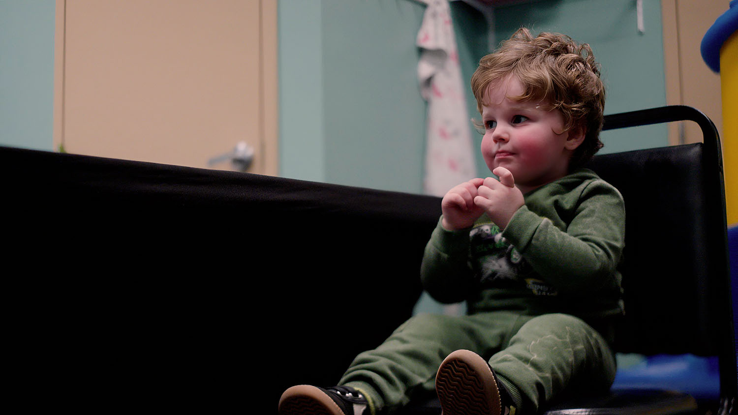 Toddler in green outfit sitting