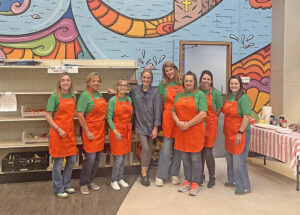 Volunteers in orange aprons at food pantry