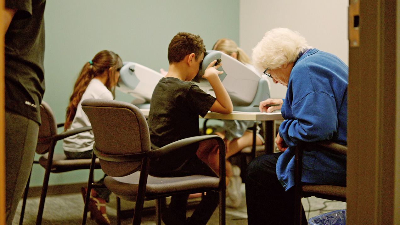 People of different ages using vision testing equipment