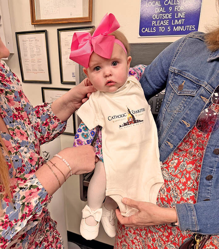 Baby in Catholic Charities onesie
