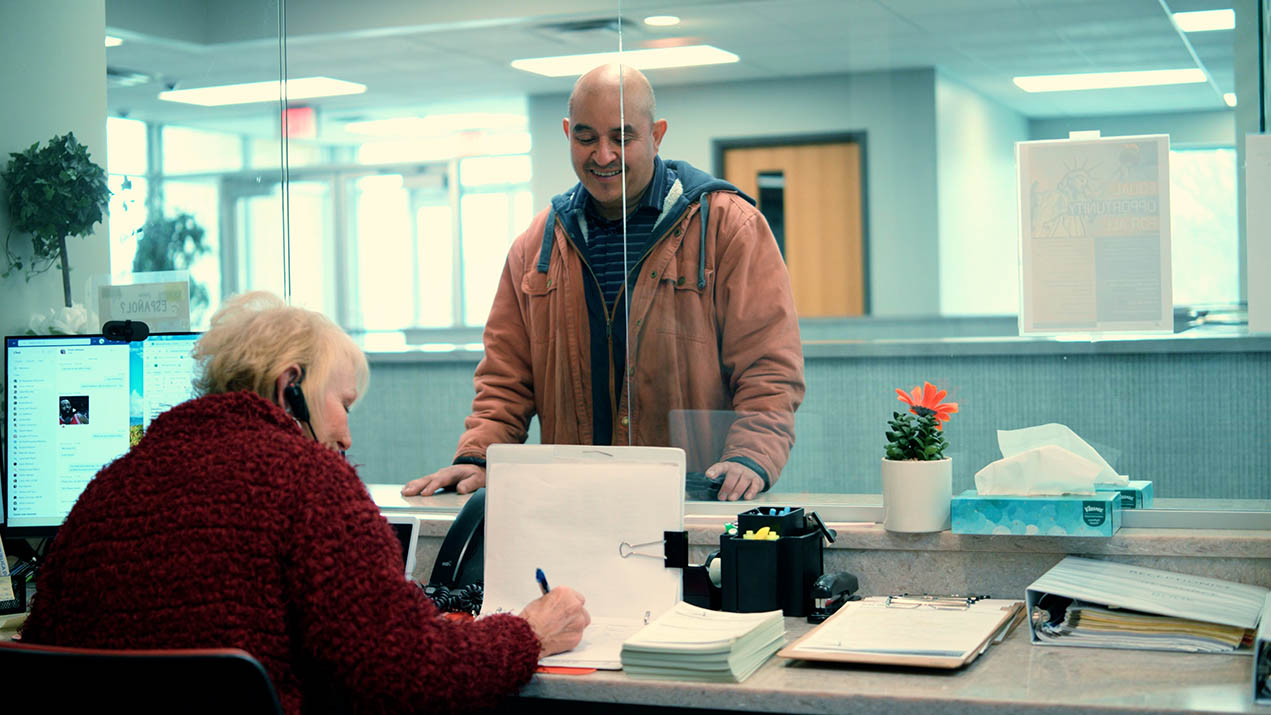 Woman at reception desk with man