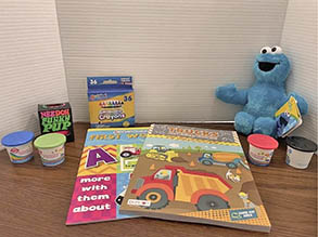 Care kit items: crayons, playdough, books, Cookie Monster
