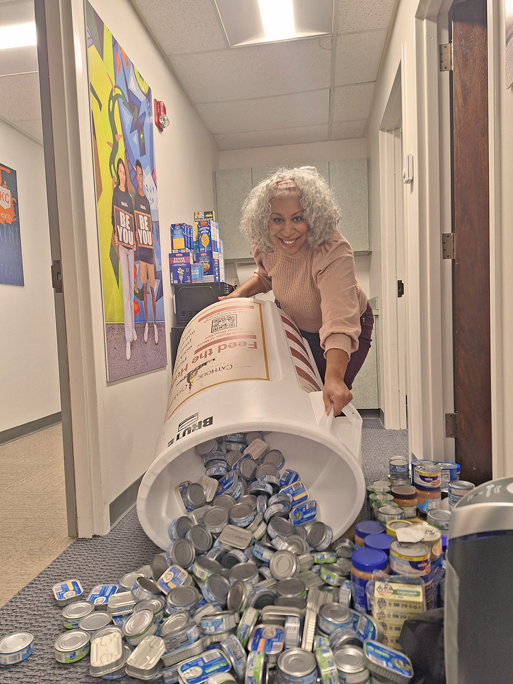 Woman tips large bin of canned food