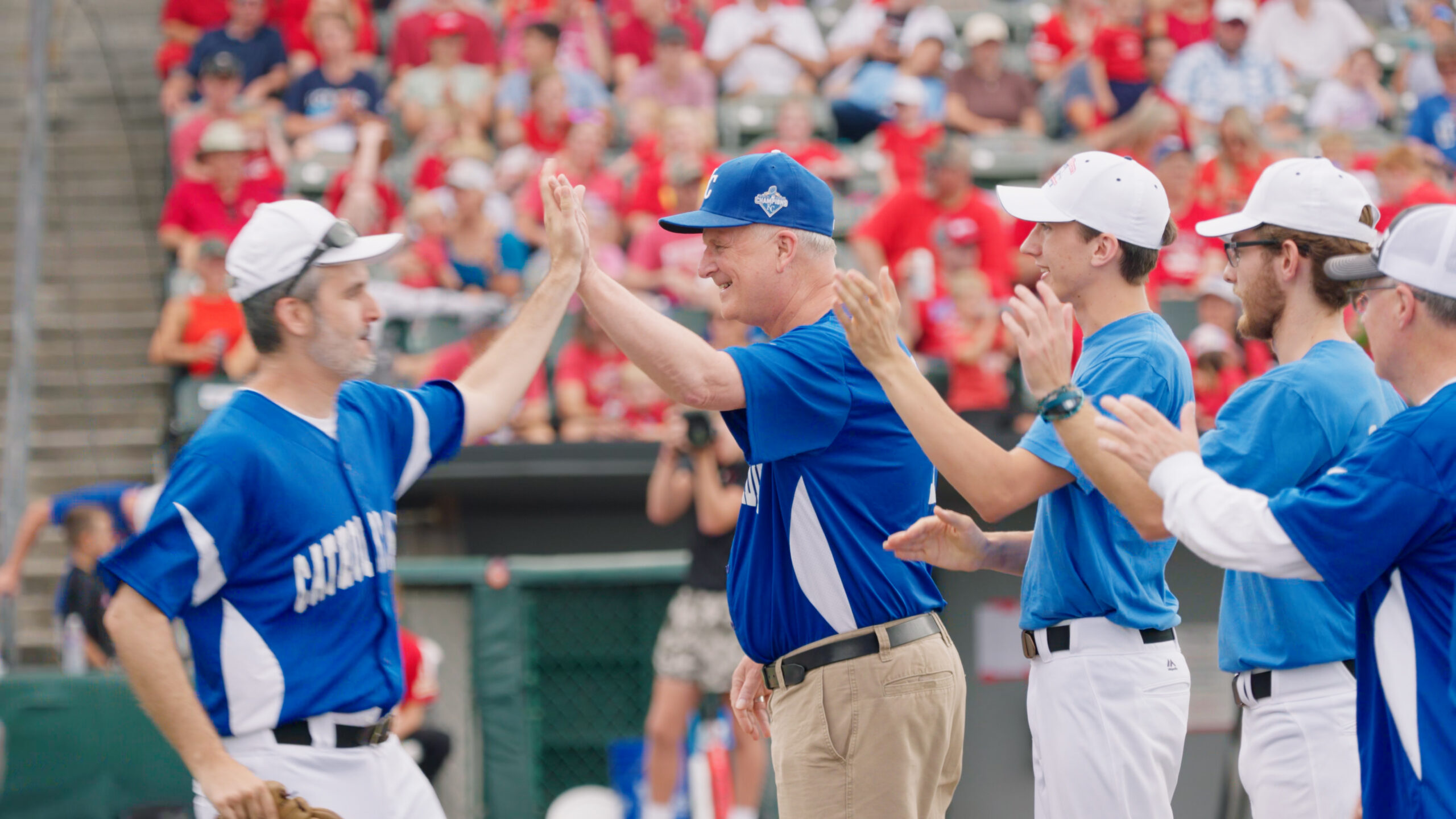 The Bishop giving a priest a high five at a softball game.