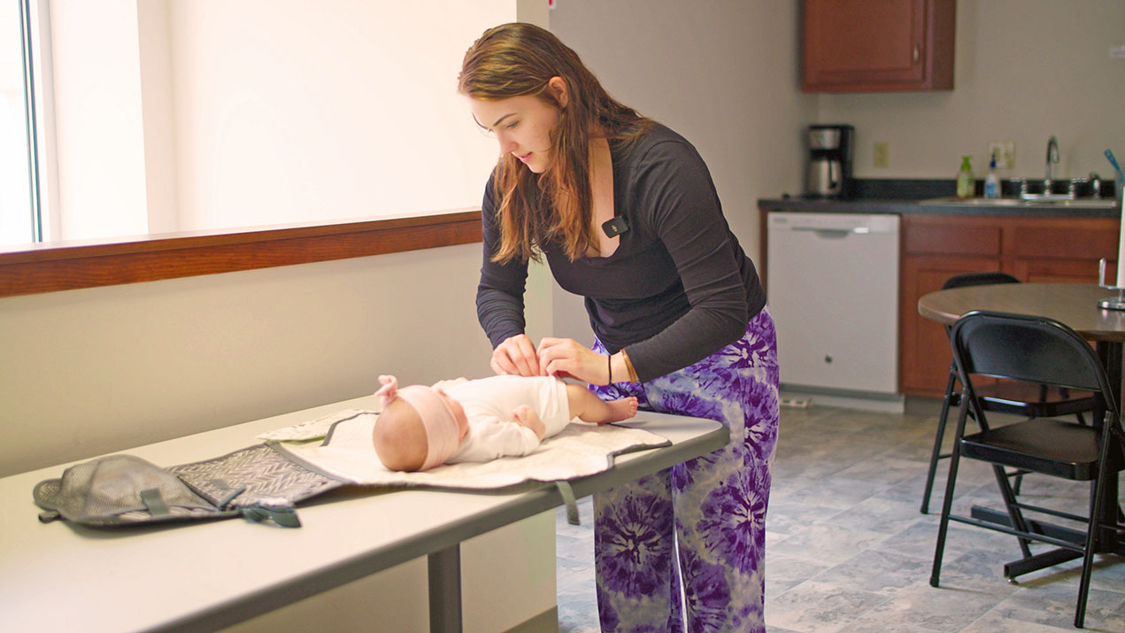 Woman changing baby on changing table