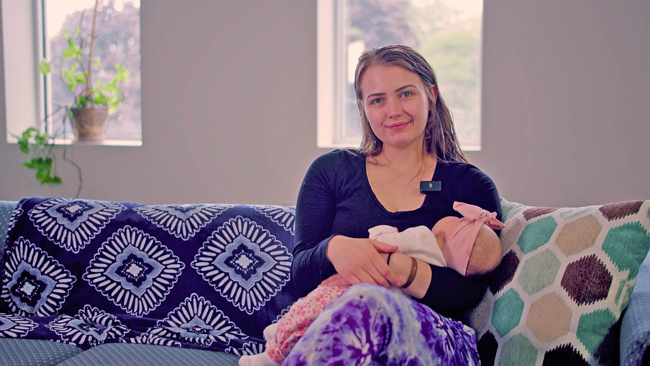 Woman holding baby on a couch
