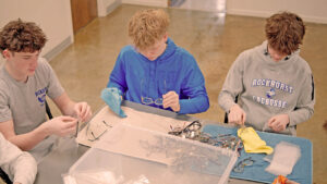 Boys cleaning eyeglasses at table
