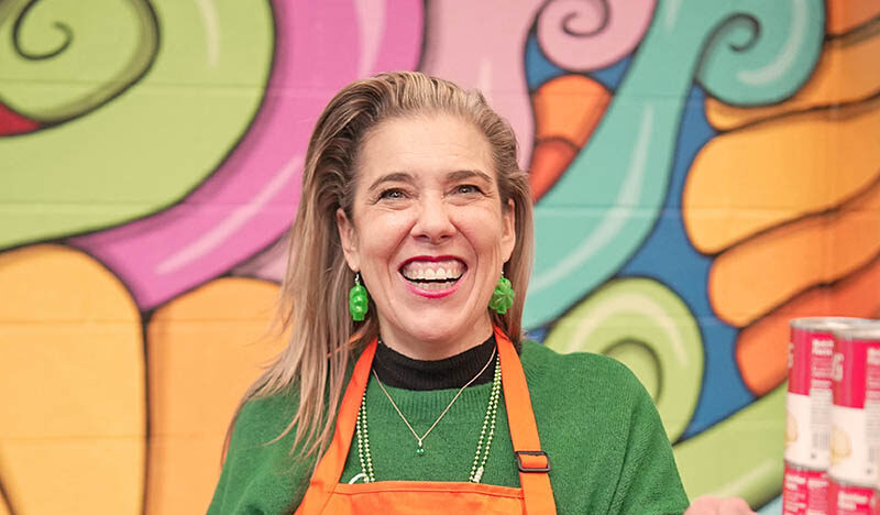 Woman in orange apron at Catholic Charities