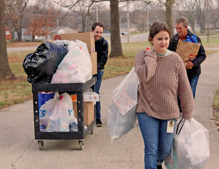 Volunteers carry Christmas gift donations