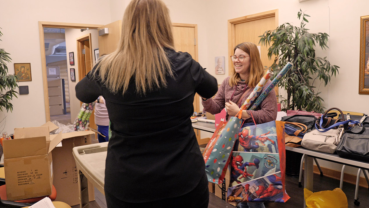 Woman holding gifts and wrapping paper
