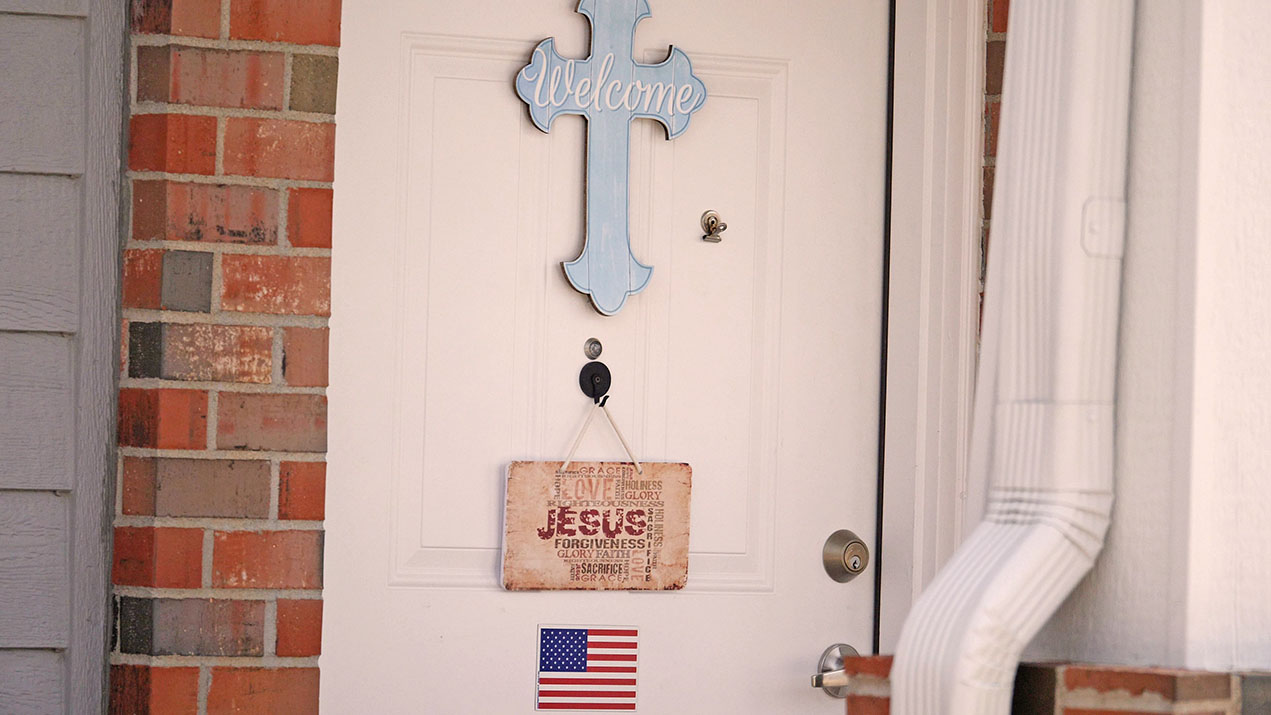 Front door with cross and welcome sign