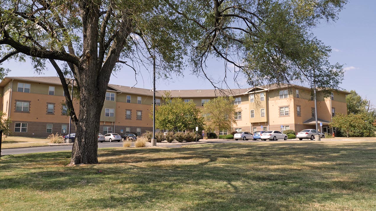 Apartment building with trees and cars