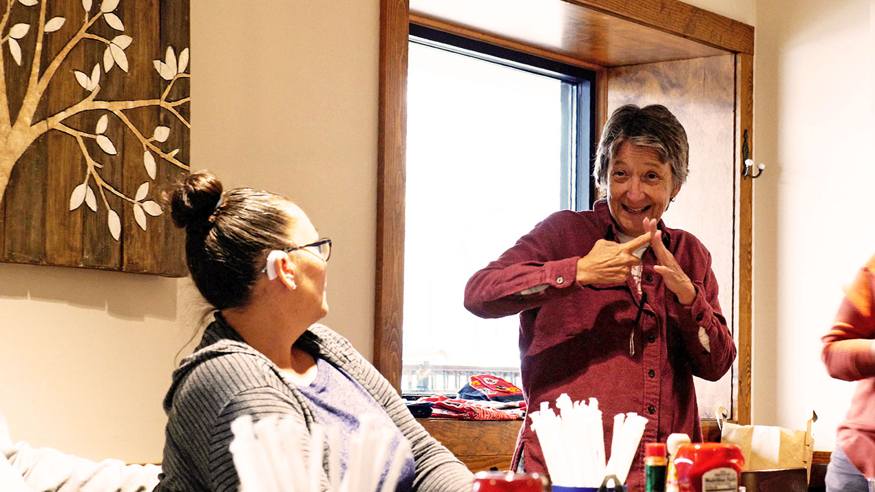 Two women signing at a table
