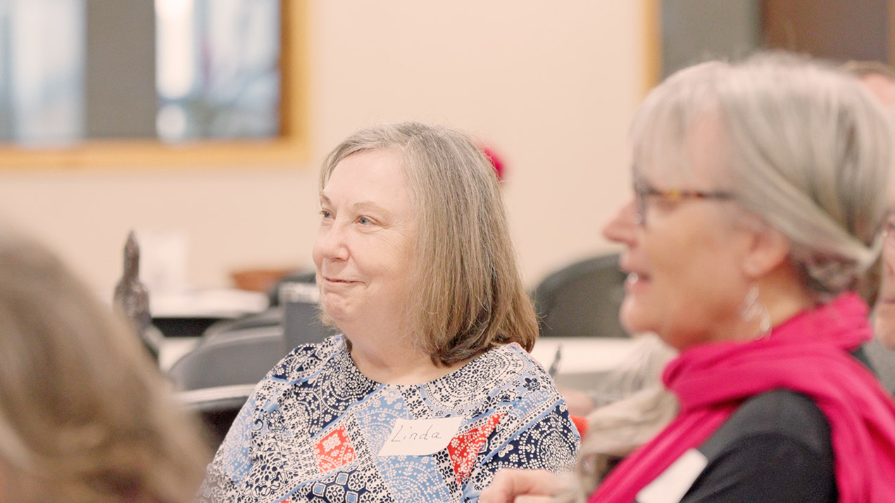 Woman named Linda smiles at group