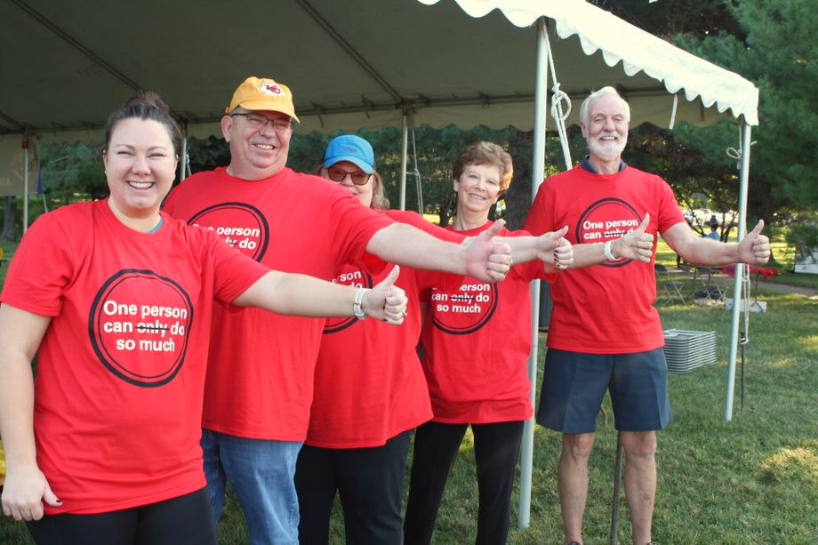 Volunteers in red shirts giving thumbs up